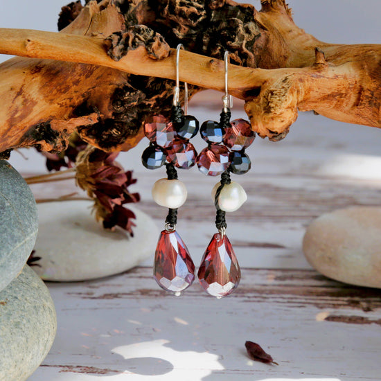 Beaded earrings with red and black crystal stones hanging on a branch and a natural pearl nestled in the black cord. 
Set on sterling silver hoops with a length of  4.3cm